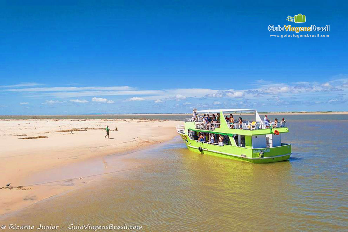 Imagem barco verde de passeio aguardando turistas para passeio pelo delta.